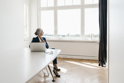 Geschäftsfrau arbeitet am Laptop im Büro - KNSF01838