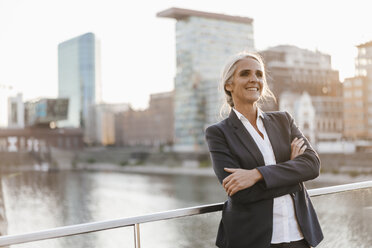 Confident businesswoman standing on bridge - KNSF01842