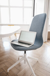Laptop auf einem Stuhl im Büro - KNSF01848