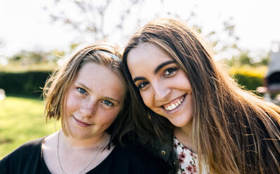 Portrait of two smiling girls outdoors - MGOF03425