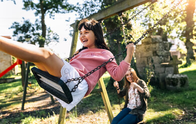 Drei glückliche Mädchen auf einem Spielplatz - MGOF03446