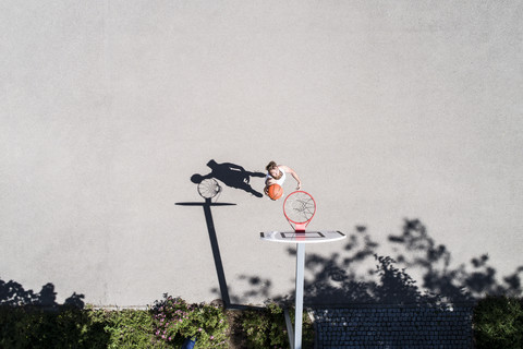 Mann spielt Basketball auf einem Platz im Freien, lizenzfreies Stockfoto