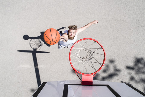 Man playing basketball on outdoor court stock photo