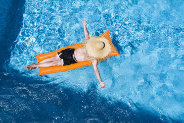 Mann entspannt auf orangefarbener Luftmatratze im Schwimmbad - MAEF12348