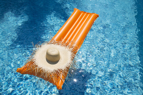 Straw hat on orange airbed in swimming pool - MAEF12349