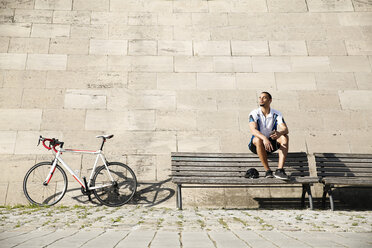 Young man with racing bicycle having a break - FKF02426