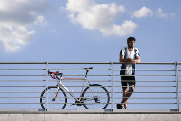 Junger Mann mit Rennrad macht eine Pause - FKF02430