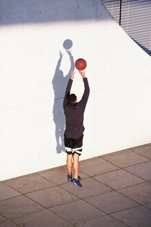 Junger Mann spielt Basketball in der Stadt - FKF02440