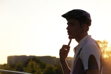 Portrait of racing cyclist at sunset - FKF02444