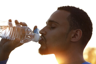Sportler trinkt Wasser aus einer Flasche - FKF02445