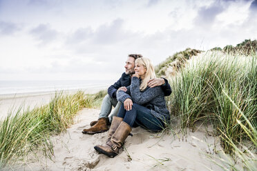 Couple sitting in dunes - FMKF04203