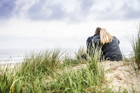 Pärchen in den Dünen sitzend, lizenzfreies Stockfoto