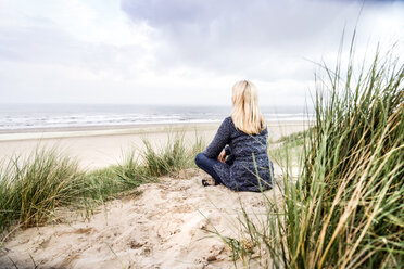 Woman sitting in dunes - FMKF04209