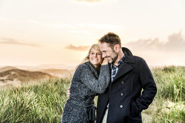 Happy couple in dunes at sunset - FMKF04219