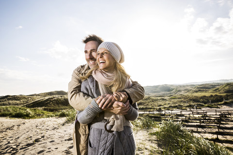 Happy couple hugging in dunes stock photo