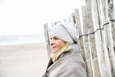 Lächelnde Frau am Zaun am Strand - FMKF04278