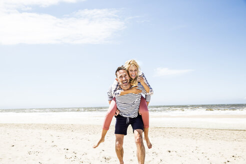 Glückliches verspieltes Paar am Strand - FMKF04301