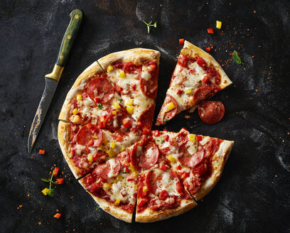 Geschnittene Pizza mit Salami auf dunklem Grund - KSWF01822