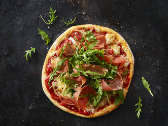 Pizza mit Schinken und Rucola auf dunklem Boden - KSWF01828