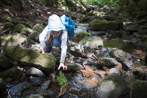 Little girl playing at brook in the woods stock photo