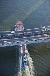 USA, New York City, Lastkahn fährt unter der Manhattan Bridge auf dem East River, Luftaufnahme - BCDF00279