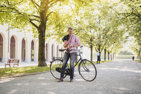 Mann mit Fahrrad in einem Park, der eine Pause macht, lizenzfreies Stockfoto