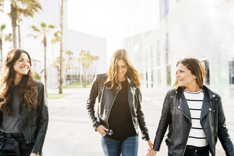 Drei glückliche Freunde in schwarzen Lederjacken, lizenzfreies Stockfoto