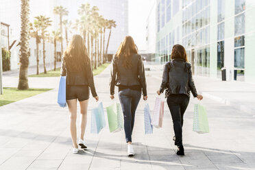 Back view of three friends with shopping bags - GIOF02951