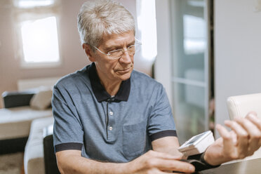 Senior man taking his blood pressure - ZEDF00745