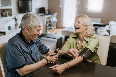 Glückliches Seniorenpaar beim Blutdruckmessen - ZEDF00763