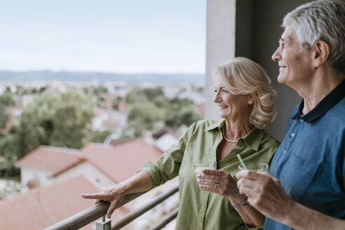 Lächelndes älteres Paar auf dem Balkon mit Blick auf die Aussicht - ZEDF00790