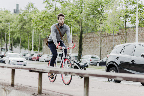 Young man riding racing cycle stock photo