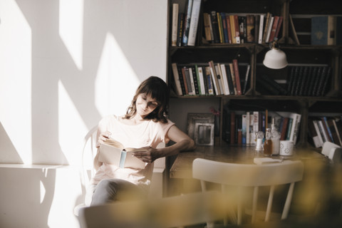 Frau liest Buch in einem Cafe, lizenzfreies Stockfoto