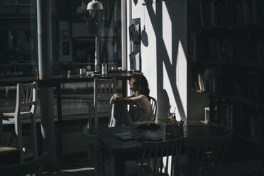 Frau genießt die Sonne, sitzt in einem Cafe - KNSF01874