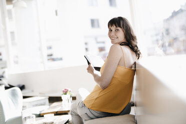 Woman sitting in cafe, using tablet pc - KNSF01877