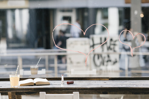 Buchen und trinken in einem Café mit Lippenstift Herzen auf Fenster gemalt - KNSF01884