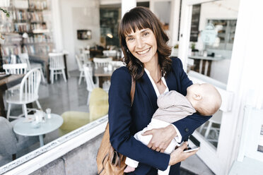 Businesswoman in cafe holding sleeping baby - KNSF01915
