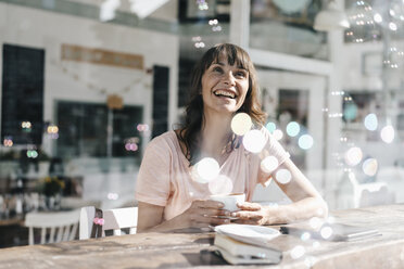 Woman sitting cafe, watching soap bubbles - KNSF01933