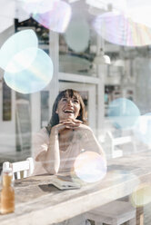 Woman sitting cafe, watching soap bubbles - KNSF01934