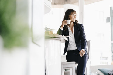 Geschäftsfrau sitzt im Café und trinkt Kaffee - KNSF01946