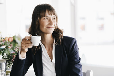 Geschäftsfrau sitzt im Café und trinkt Kaffee - KNSF01947