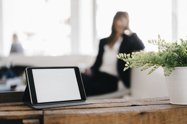 Geschäftsfrau in einem Café mit digitalem Tablet im Vordergrund - KNSF01950