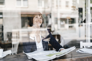 Businesswoman sitting cafe, reading newspaper - KNSF01962