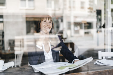 Geschäftsfrau sitzt in einem Café und liest Zeitung - KNSF01962