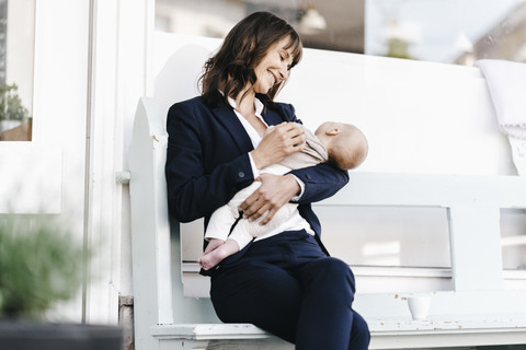 Geschäftsfrau im Café mit schlafendem Baby, lizenzfreies Stockfoto