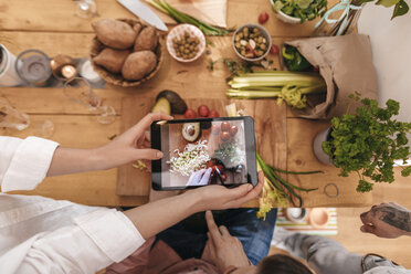 Friends cooking together taking picture of prepared vegetables with tablet, top view - GUSF00064