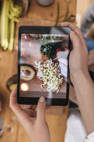 Frau fotografiert zubereitetes Gemüse mit Tablet, Nahaufnahme, lizenzfreies Stockfoto