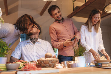 Freunde bereiten zu Hause gemeinsam Essen zu - GUSF00072