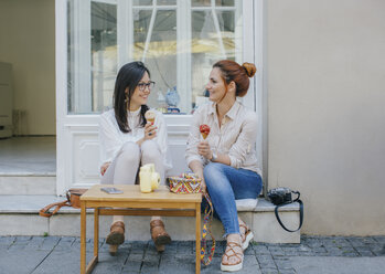 Two friends enjoying ice cream in the city - MOMF00179