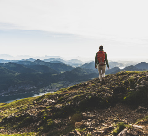 Wanderer mit Rucksack beim Wandern in den Alpen, lizenzfreies Stockfoto